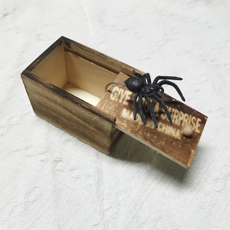 Wooden prank box with a black spider and engraved text, showcasing a fun and surprising gift for prank enthusiasts.