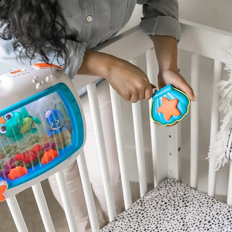 Attaching baby aquarium soother to crib